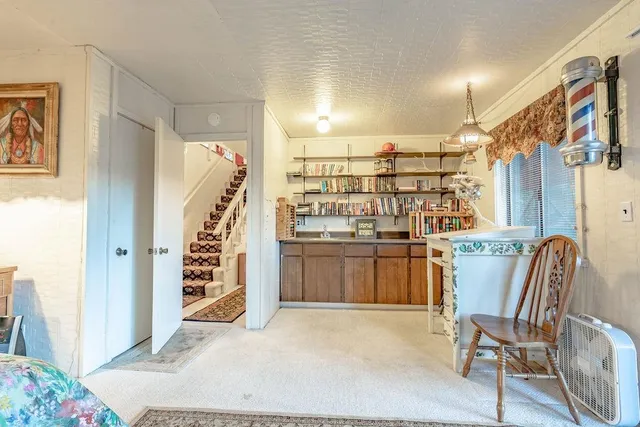 a living room with a large window and chairs