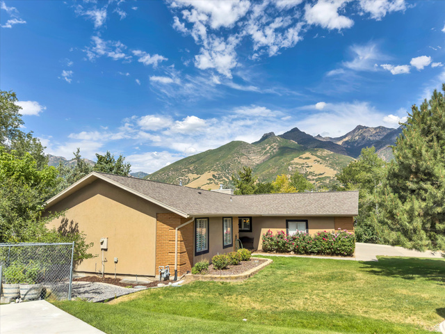 2863 Fallentine Road Sandy, UT 84093 - Photo 5 of 48 Ranch-style residence featuring a stucco and brick exterior, dark-trimmed windows, and a shingle roof