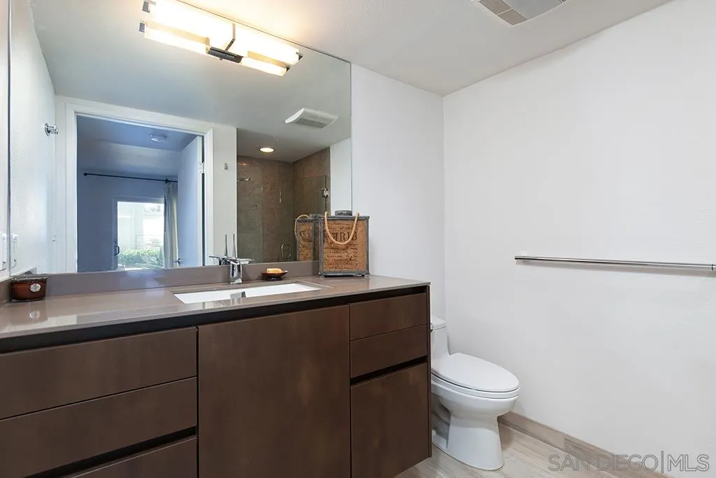 940 Sealane Drive, Unit 3 Encinitas, CA 92024 - Photo 16 of 23 a bathroom with a granite countertop sink a toilet and mirror