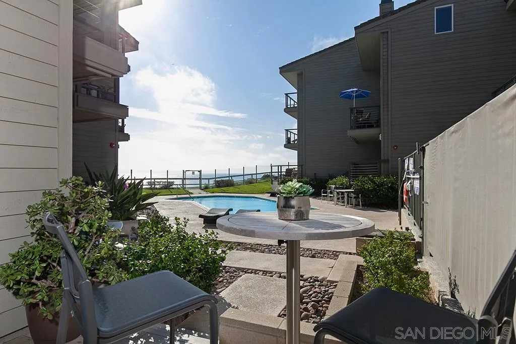 940 Sealane Drive, Unit 3 Encinitas, CA 92024 - Photo 18 of 23 a view of a patio with table and chairs plants and wooden fence