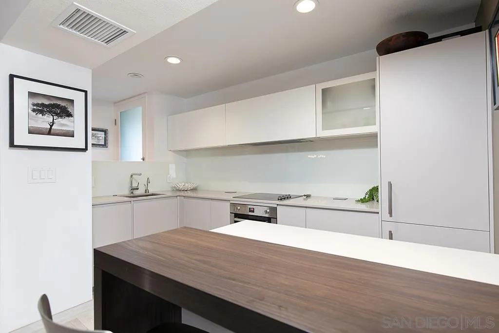 940 Sealane Drive, Unit 3 Encinitas, CA 92024 - Photo 9 of 23 a kitchen with a wooden floor and a refrigerator