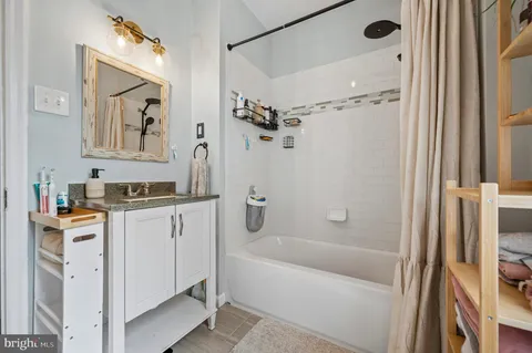 a bathroom with a tub a sink and a mirror
