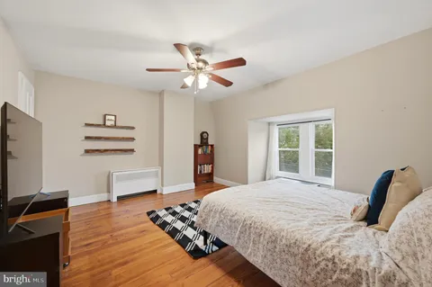 a bedroom with a large bed and a flat tv screen on dresser