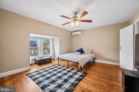 a bedroom with a bed and wooden floor