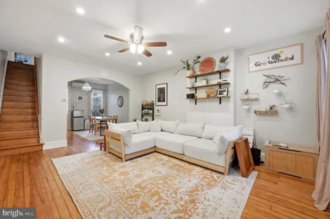 a living room with furniture and a wooden floor