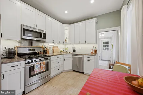 a kitchen with stainless steel appliances granite countertop a sink a stove a microwave and cabinets