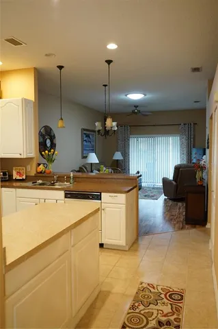 a kitchen with kitchen island granite countertop a sink a counter top space and living room view