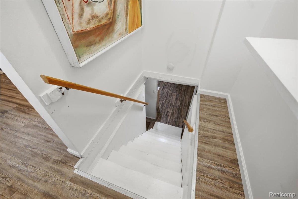 5307 Drayton Road Clarkston, MI 48346 - Photo 24 of 46 Staircase featuring white risers and treads, a natural wood handrail, and white walls