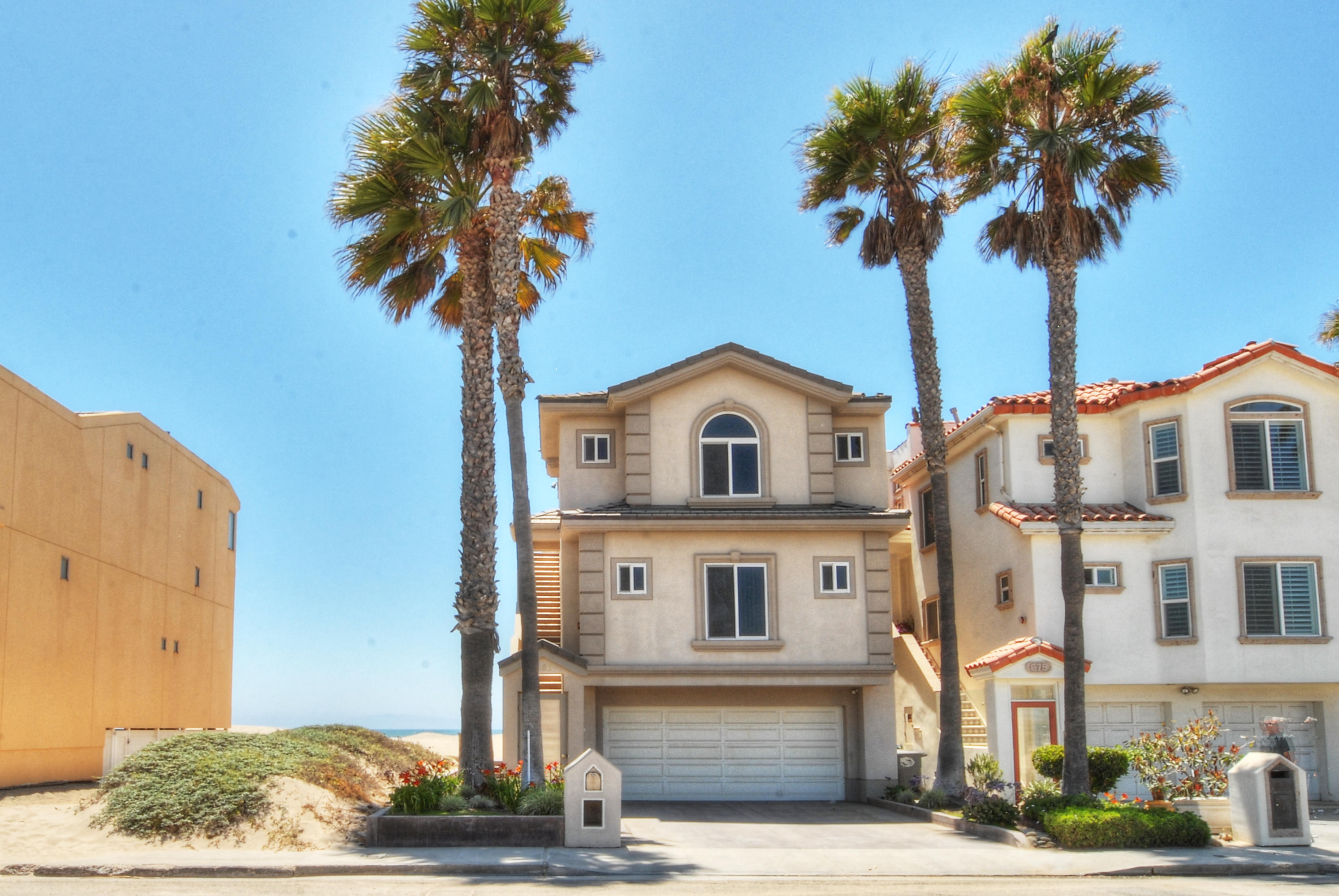 681 Mandalay Beach Road Oxnard, CA 93035 - Photo 2 of 39 a front view of a house with a garden and trees