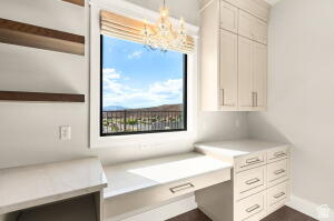 1141 East Lost Ridge Drive Washington, UT 84780 - Photo 43 of 108 Integrated desk area featuring a large window, built-in cabinetry, wood-finish floating shelves, and a decorative chandelier
