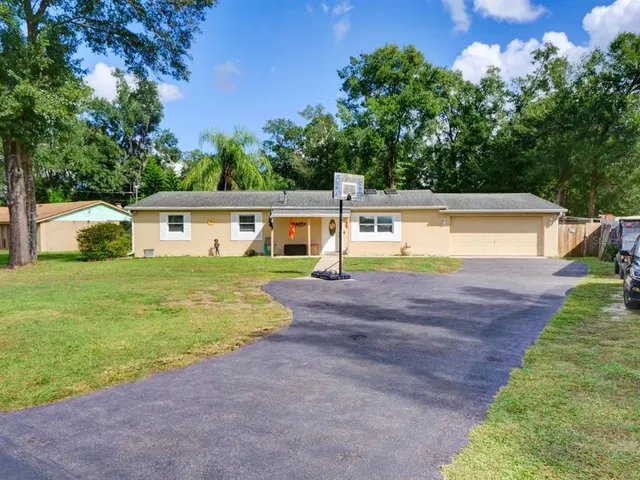 a view of a house with swimming pool and a yard