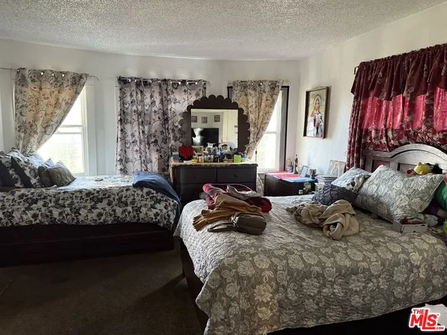 a bedroom with two beds and a large window