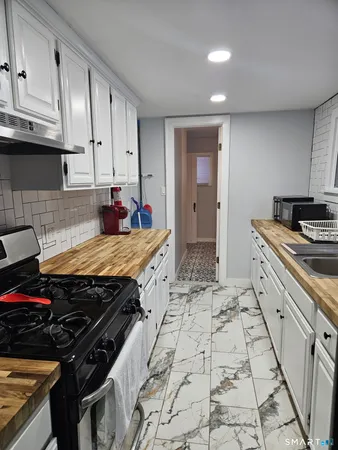 a kitchen with stainless steel appliances a stove a sink and cabinets