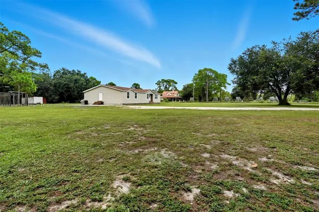 a view of a big yard with large trees