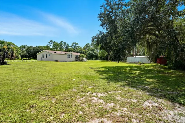 a view of a big yard with trees in the background