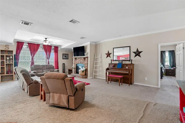 a living room with furniture kitchen view and a large window