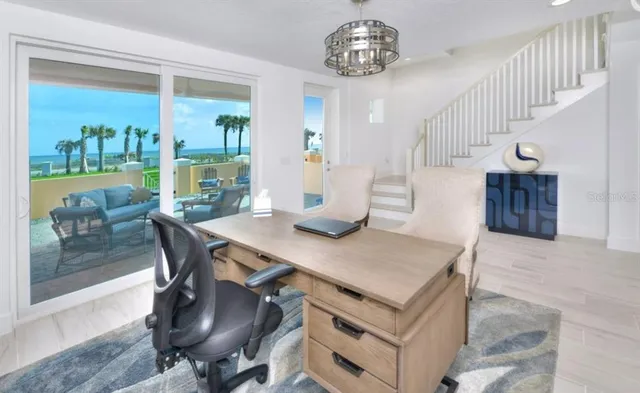 a view of a dining room and livingroom with furniture wooden floor a rug a potted plant and a chandelier