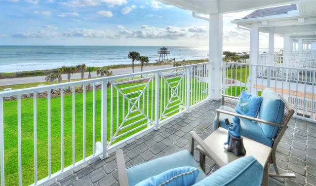 a view of a patio with couches chairs potted plants and wooden floor