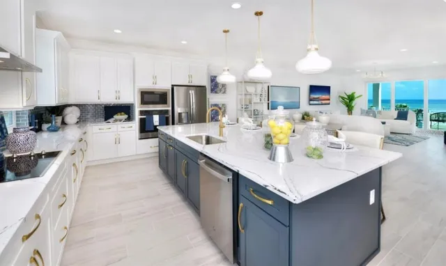 a kitchen with stainless steel appliances kitchen island granite countertop a sink a stove and a refrigerator