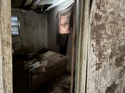 a bed sitting in a bedroom next to a window