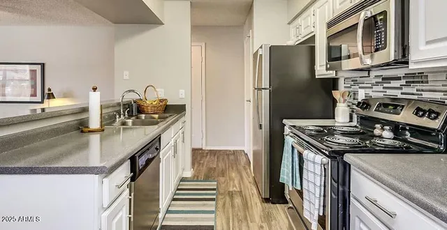 a kitchen with stainless steel appliances granite countertop a stove and a refrigerator