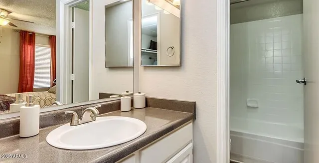 a bathroom with a granite countertop sink and a mirror