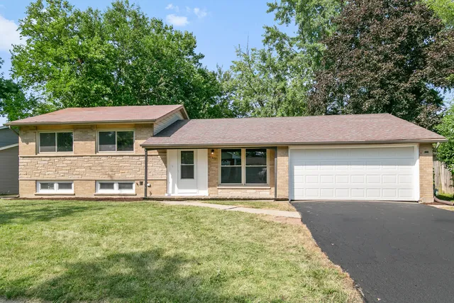 a front view of a house with a garden and yard