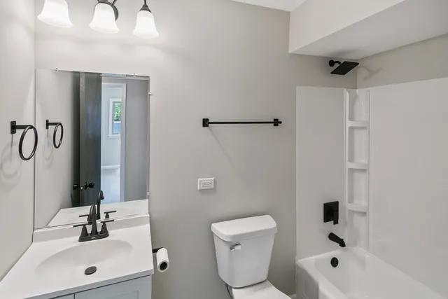 a bathroom with a toilet sink shower and mirror