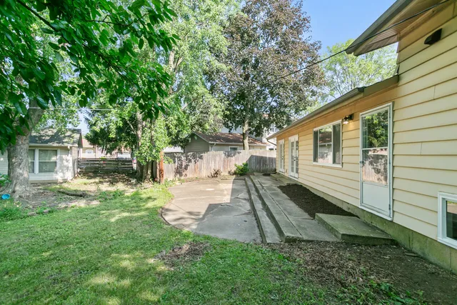 a view of a yard with a house and a large tree