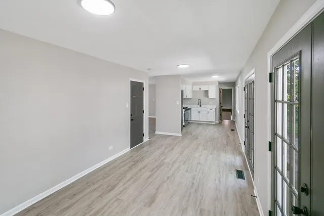 a view of a big room with wooden floor and windows