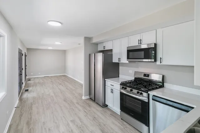 a kitchen with stainless steel appliances granite countertop a stove a refrigerator and a microwave