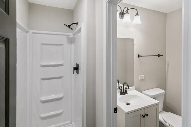 a bathroom with a sink a toilet and shower