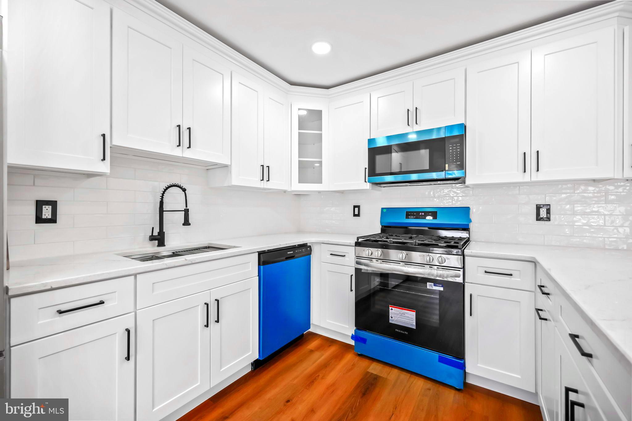 61 Argonne Avenue Hamilton, NJ 08620 - Photo 14 of 38 a kitchen with cabinets stainless steel appliances a sink and wooden floor