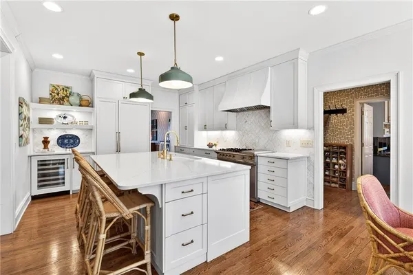 a kitchen with kitchen island a stove a chandelier and wooden floor