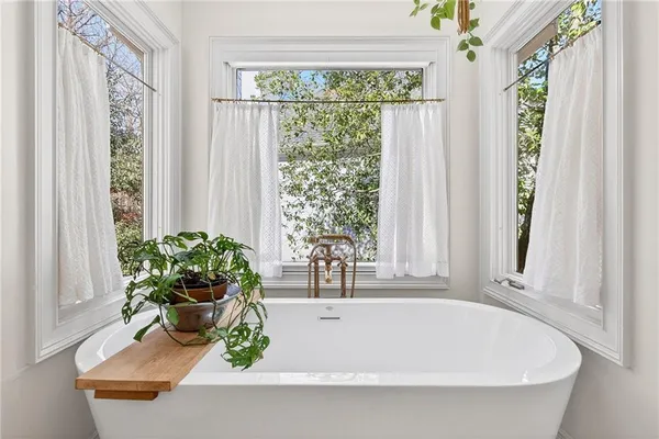 a white bath tub sitting in front of a window
