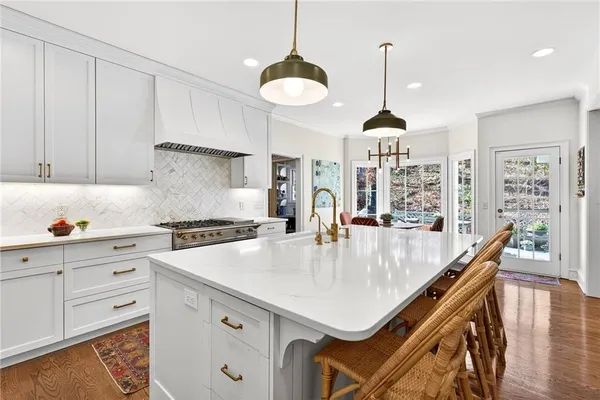 a kitchen with stainless steel appliances a table a stove and cabinets