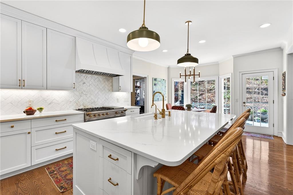 3642 Mayfair Road Northeast Atlanta, GA 30305 - Photo 7 of 40 a kitchen with stainless steel appliances a table a stove and cabinets