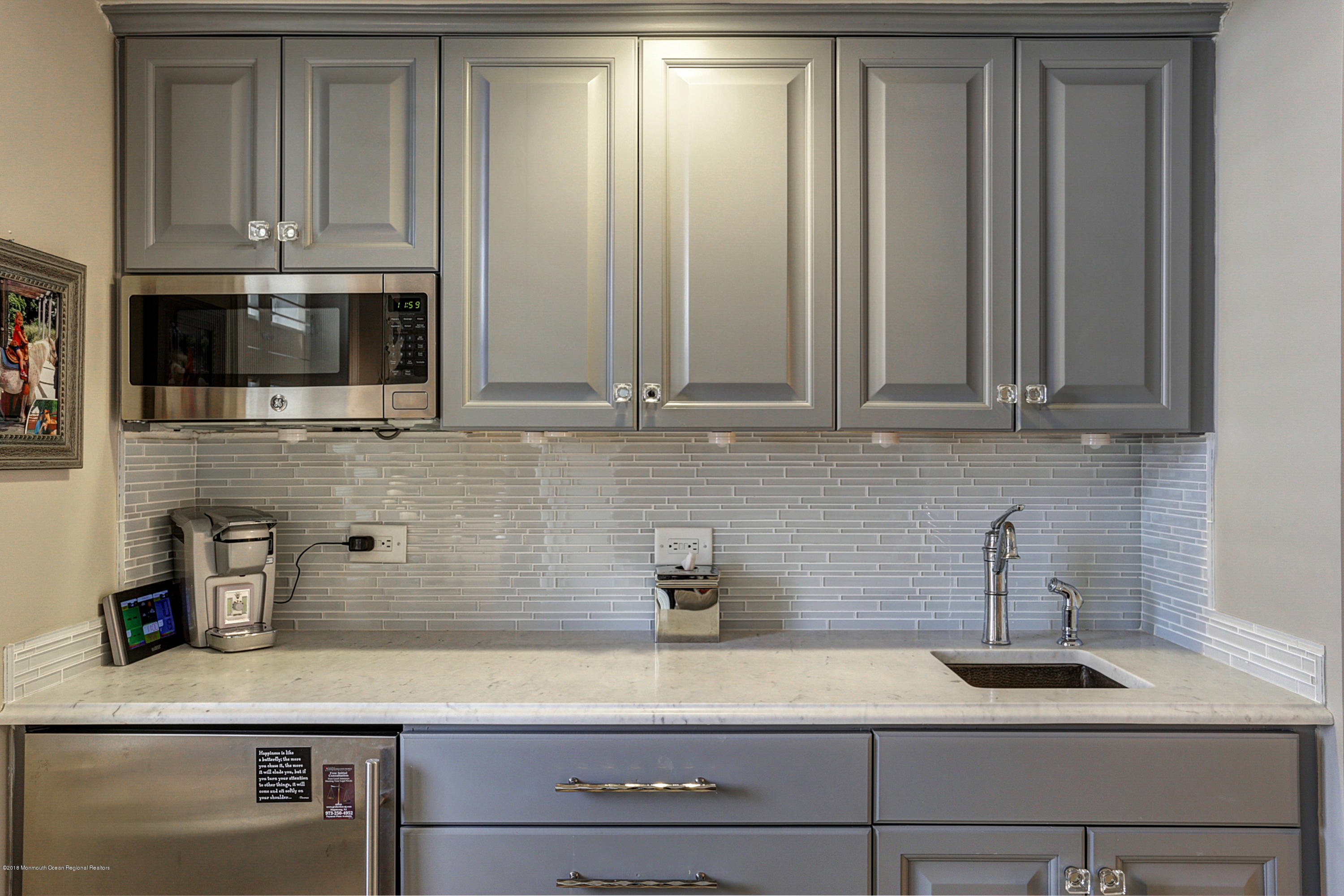 700 Ocean Avenue, Unit 437 Spring Lake, NJ 07762 - Photo 5 of 24 a kitchen with stainless steel appliances granite countertop white cabinets and a microwave