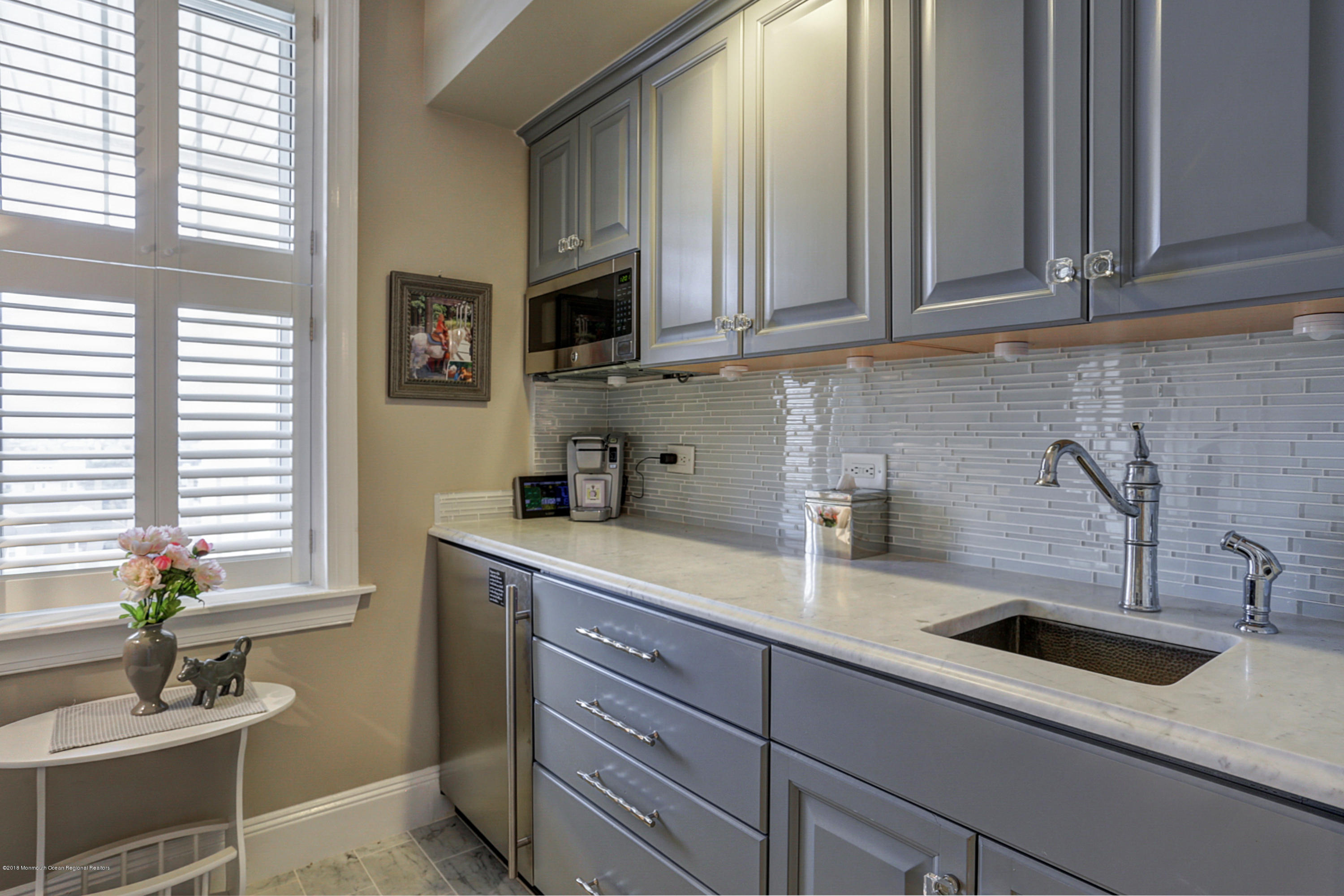 700 Ocean Avenue, Unit 437 Spring Lake, NJ 07762 - Photo 6 of 24 a kitchen with stainless steel appliances granite countertop a sink a window and white cabinets