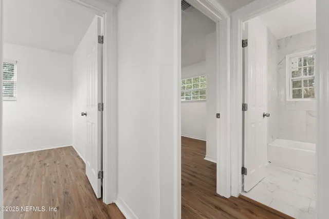 a view of a hallway with wooden floor