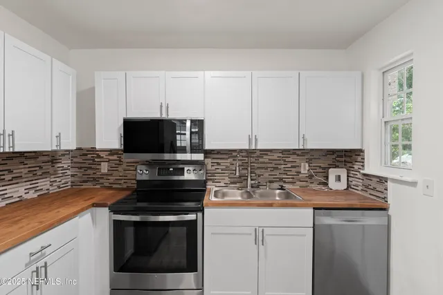 a kitchen with stainless steel appliances granite countertop a stove microwave and sink