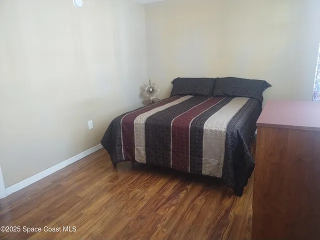 a bed sitting in a bedroom next to a wooden cabinet