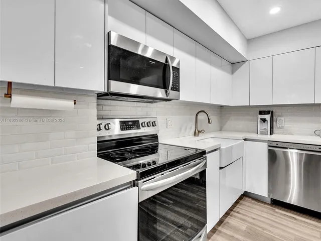 a kitchen with stainless steel appliances a sink a stove and microwave