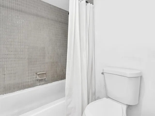 a white toilet sitting next to a bath tub