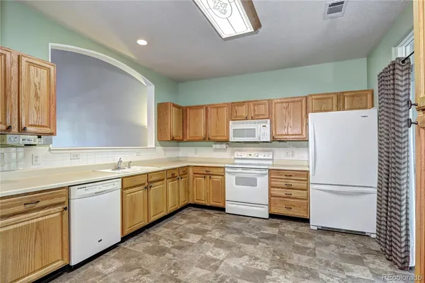 a kitchen with white cabinets and white appliances