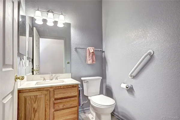 a bathroom with a granite countertop toilet sink and mirror
