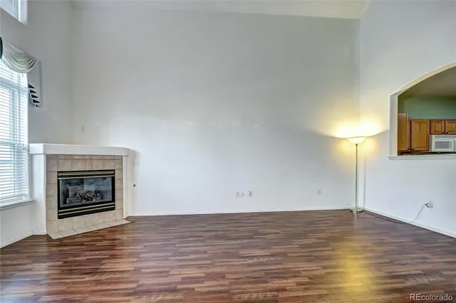 a view of empty room with wooden floor and fireplace