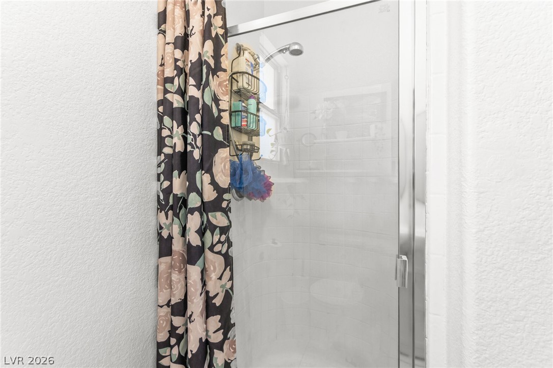 7353 Ridge Star Court Las Vegas, NV 89131 - Photo 32 of 36 A well-maintained shower with sleek glass enclosure and overhead showerhead.