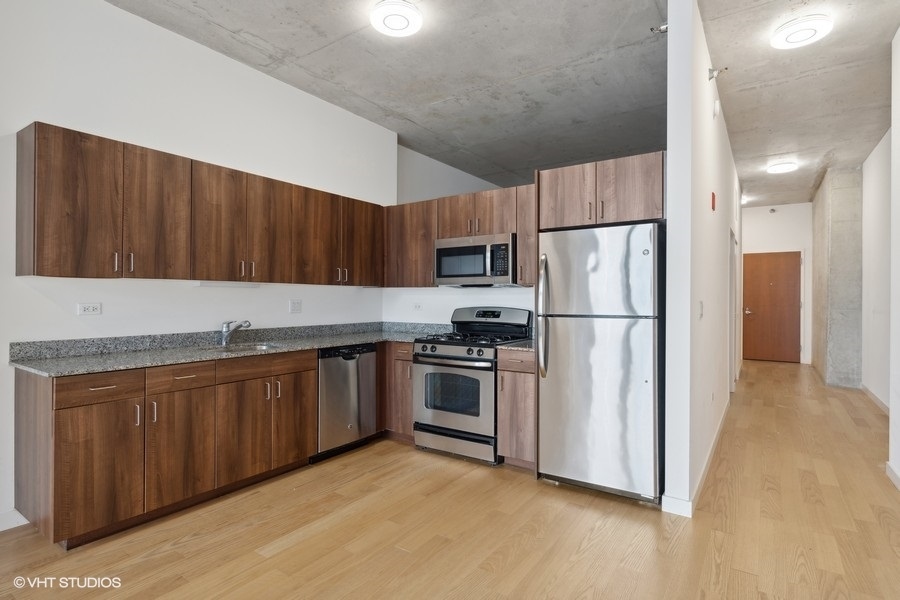 235 West Van Buren Street, Unit 4121 Chicago, IL 60607 - Photo 12 of 25 a kitchen with stainless steel appliances granite countertop a refrigerator stove a sink and a granite counter tops