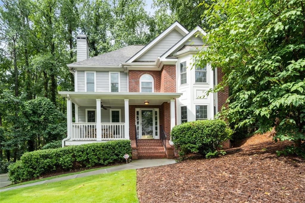 a view of a white house with large windows and a small yard